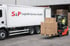 Ein Gabelstapler lädt Kartons auf einen weißen S&P Logistik Service GmbH LKW.