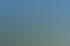 Modernes Apartmentgebäude mit Balkonen, Solarmodulen und grünen Bäumen unter blauem Himmel.