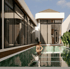 A person standing in a swimming pool next to a Luxury villa built by JDH in Bali