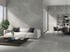 Graues Wohnzimmer mit Natursteinwand, hellem Sofa und Couchtisch