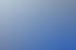 Heckscheibe eines blauen Autos mit Wassertropfen und Scheibenwischer, reflektiert eine helle Umgebung.
