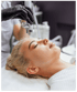 Kosmetische Gesichtsbehandlung einer Frau mit einem Hydrafacial-Gerät durch eine Person mit schwarzen Handschuhen.