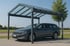 Graues Kombi-Auto steht unter einem modernen Carport mit Glasdach und grauer Metallkonstruktion.