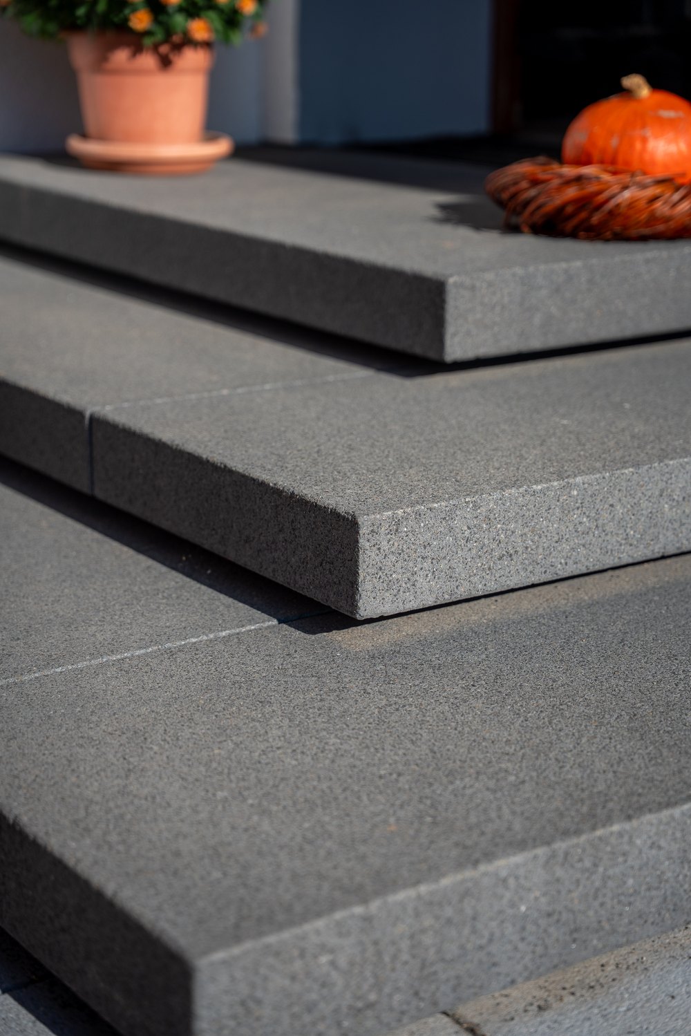 Dunkelgraue Granitstufen mit Terrakottatopf
