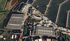 Luftaufnahme eines Yachthafens mit vielen Booten, Gebäuden mit Solarpaneelen und einem großen Parkplatz.