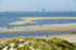 Kitesurfer an einem Ausweichspot in den Niederlanden mit Dünen und flachem Wasser bei Sonnenschein