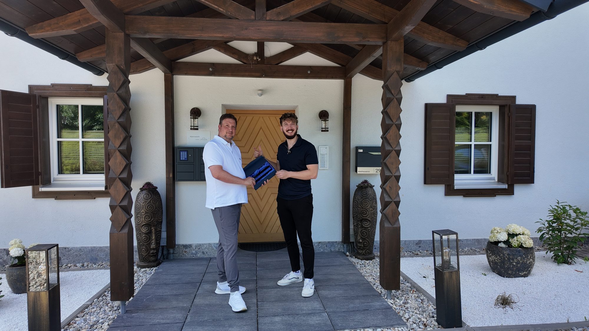 Philipp Mohnhaupt und Niklas Kuhn vor der Villa Alpenrausch am Königssee bei der Übergabe des 10.000-Euro-Awards