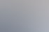 Drei Personen sitzen an einem Besprechungstisch im Büro und unterhalten sich lächelnd während eines Meetings.