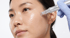 Eine Person erhält eine Microneedling-Behandlung im Gesicht mit einem elektrischen Dermapen durch eine behandschuhte Hand.