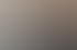 Frau mit Brille telefoniert am Schreibtisch, ein Stift in der Hand; Computerbildschirme und Aktenordner im Hintergrund.