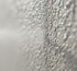 Nahaufnahme der Textur eines pH-neutralen Reinigungsmittels auf einer Putzfassade in Wolfsburg und Braunschweig: Das Bild zeigt eine mikroskopische Ansicht der Interaktion zwischen dem Reinigungsmittel und der Struktur des Putzes. Es werden keine Reinigungswerkzeuge oder Personen gezeigt, um den Fokus auf die schonende Reinigung zu legen. Optimale Fassadenreinigung in Wolfsburg und Braunschweig