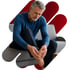 Gray-haired man in a blue shirt grips his foot, wincing at neuropathy pain.