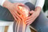 A person holds their knee, illuminating need of a2m injections.