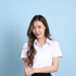 Young Asian woman with long brown hair, wearing a white short-sleeved collared shirt, smiling at the camera.