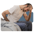 Man sitting on bed, holding head and back, showing chronic fatigue.