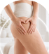A woman makes a heart shape with their hands on their thigh, highlighting skin texture and cellulite.