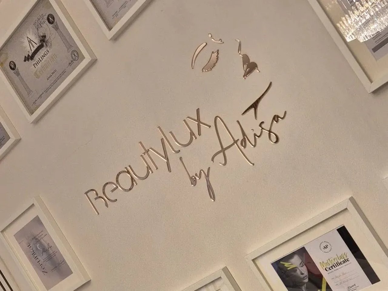 Wand mit Zertifikaten und BeautyLux-Logo im Studio
