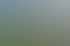 Menschenmenge auf einer Wiese vor der modernen Tribüne der Pferderennbahn Longchamp in Paris bei sonnigem Wetter.