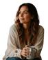 Eine Frau mit lockigem Haar hält eine Tasse und blickt zur Seite.