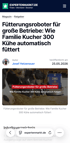 Ein blauer automatischer Fütterungsroboter verteilt Futter an Kühe in einem modernen Stallgebäude.