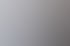 Ein Mann und eine Frau stehen lächelnd an einem weißen Empfangstresen in einem modernen Büro.