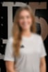 Lächelnde Frau mit langen blonden Haaren im weißen T-Shirt vor einem Hintergrund im Pier5