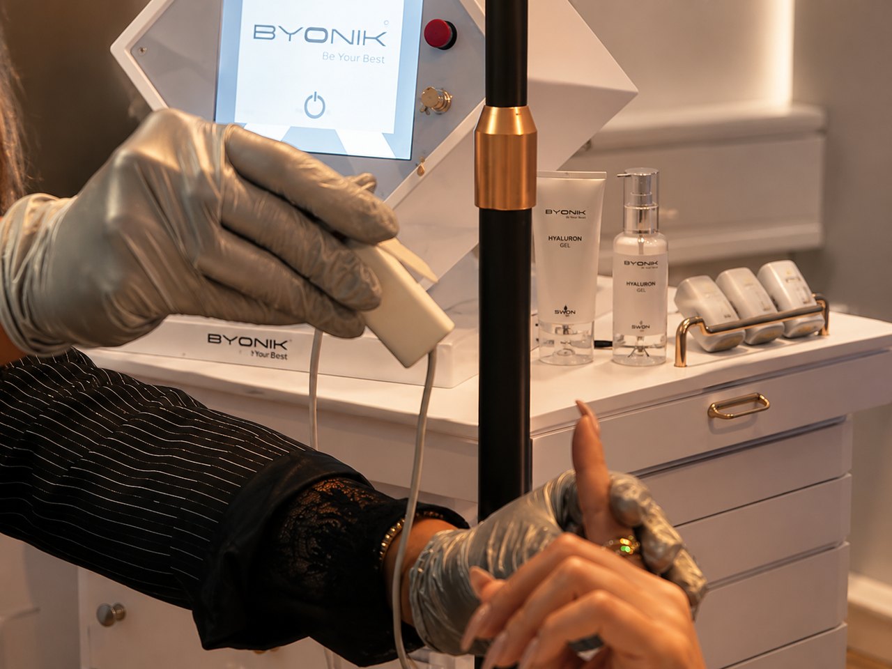 BYONIK®-Lasergerät mit bereitgelegten Handstücken und Hyaluron-Gelen am hygienisch vorbereiteten Arbeitsplatz im SWON Studio in Pforzheim