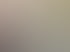 Eine lächelnde Frau mit Brille telefoniert am Schreibtisch im Büro, während eine Kollegin im Hintergrund am Computer arbeitet.