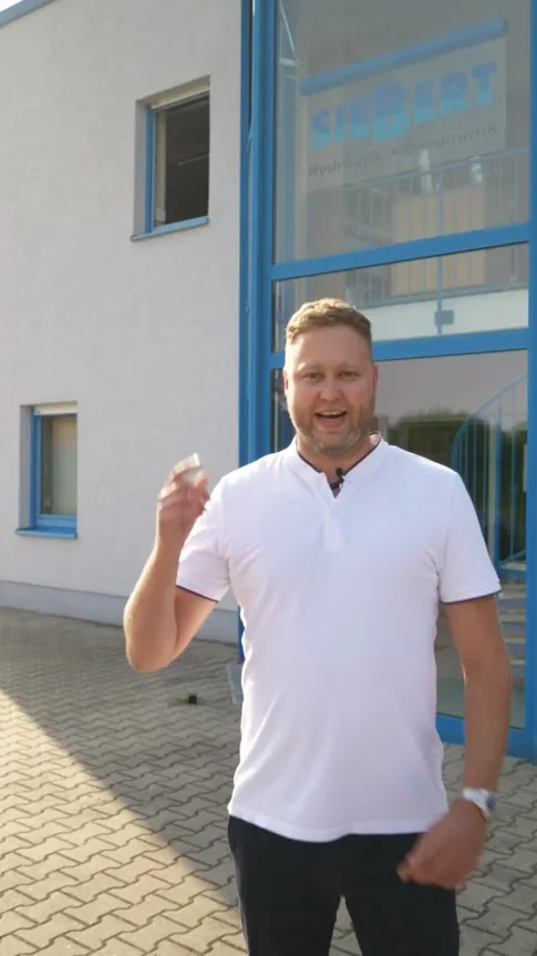 Ein Mitarbeiter vor dem Unternehmensgebäude von Siebert
