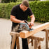 Handwerker schneidet einen Holzbalken auf Sägeböcken mit einer Mafell Handkreissäge im Freien.