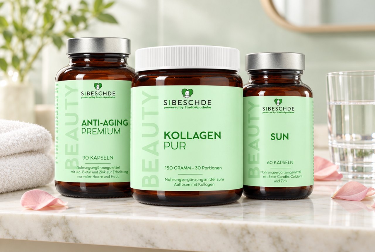 S|BESCHDE Anti-Aging Premium, Kollagen Pur und Sun auf einer hellen Marmorablage im Bad mit Handtuch, Rosenblättern und Glas Wasser