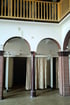 Zwei Umkleidekabinen mit Vorhängen unter Bögen und einer Holzbalustrade im Obergeschoss.