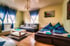 Helles Wohnzimmer mit zwei Sofas, Couchtisch, blauen Vorhängen und Holzfußboden.