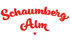 Roter Text "Schaumberg Alm" in kursiver Schrift, mit einem kleinen roten Herz unter "Alm".