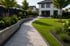 Geschwungener grauer Steinweg durch einen grünen Garten mit Rasen, Blumenbeeten und modernem weißen Haus.