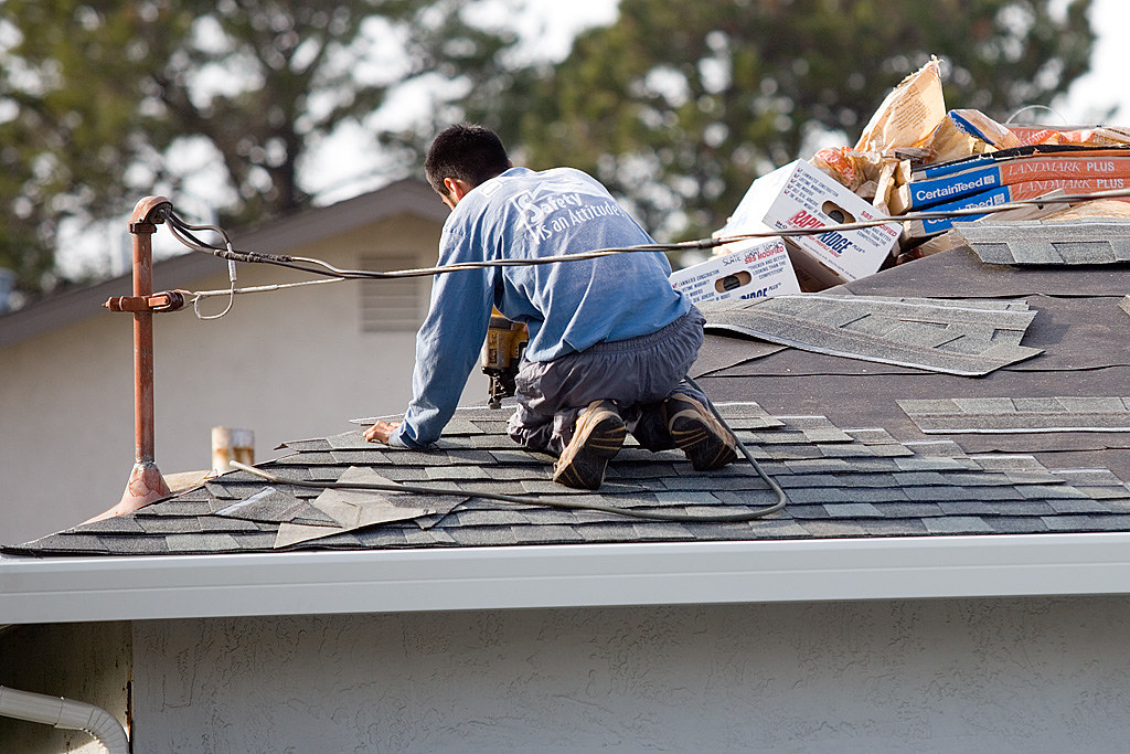 Roofing crew stripping an old shingle roof back to the decking