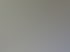 Arbeitsplatz mit einem weißen Tisch, schwarzen Regalen, technischer Ausrüstung und einem Bürostuhl.