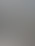 Eine weiße Fujitsu-Klimaanlage steht auf schwarzen Halterungen auf einem gefliesten Balkon neben einer weißen Wand.
