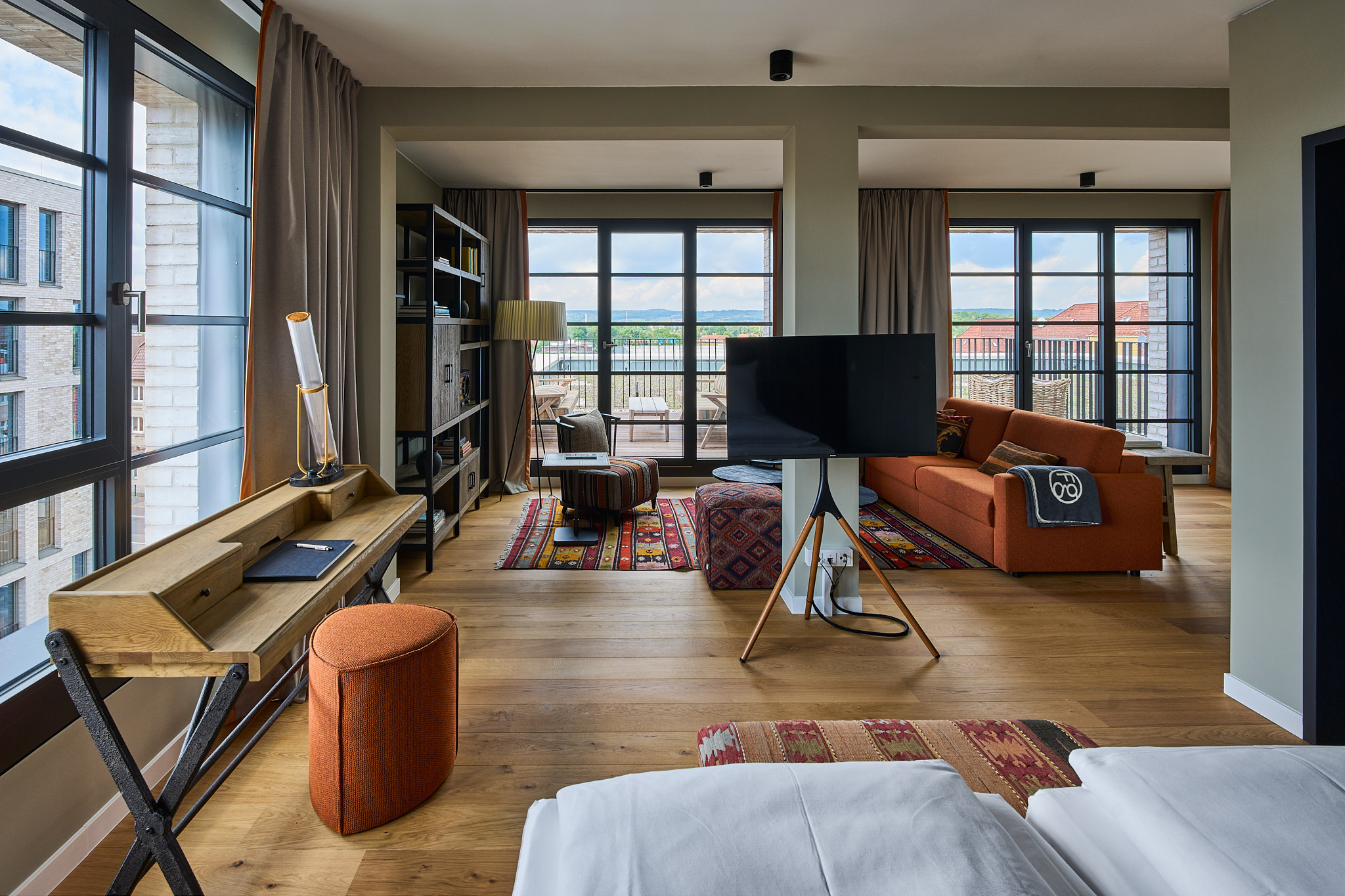 FREIgeist Göttingen Nordstadt – Hotelzimmer mit Holzboden, Wohnbereich und großen Fenstern