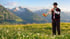 Kampagnenvisual mit Alphornspieler vor Berglandschaft