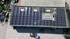 Luftaufnahme eines großen Flachdachs mit Solarmodulen und Text "400 kWp PV Leistung, Schwerte".