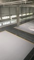 Glänzende graue Epoxidharz-Bodenbeschichtung in einer Industriehalle