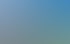 Modernes, geschwungenes Gebäude aus Glas und Stahl mit drehbarer Tür, umgeben von grünen Büschen und Rasen unter blauem Himmel.