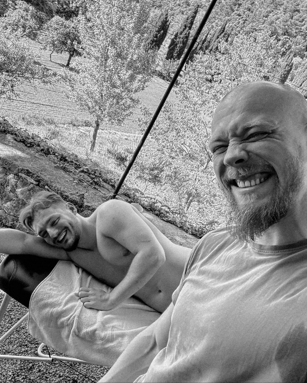 Zwei Männer lachen im Garten, Schwarz-Weiß