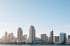 San Diego skyline with several skyscrapers under a clear blue sky, seen from across the bay.