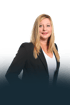 Porträt einer lächelnden Frau mit blonden Haaren, schwarzem Sakko und weißem Oberteil vor dunklem Hintergrund.