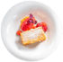 Millefeuille mit rotem Sorbet, Beeren und Minze auf weißem Teller.