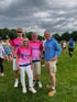 Vier Menschen auf einer Wiese, drei davon in pinken Diakonie-Laufshirts.