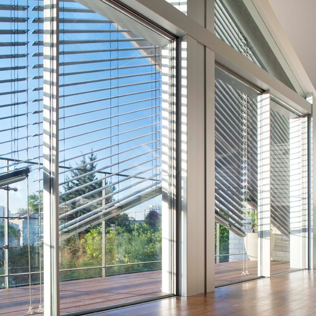 Schräg montierter Raffstore an geneigter Glasfläche