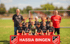 Fußballteam von Hassia Bingen mit zwei Trainern und neun Kindern in roten und schwarzen Trikots.